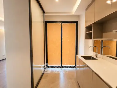 Modern kitchen with sleek cabinetry and large windows in a contemporary apartment.