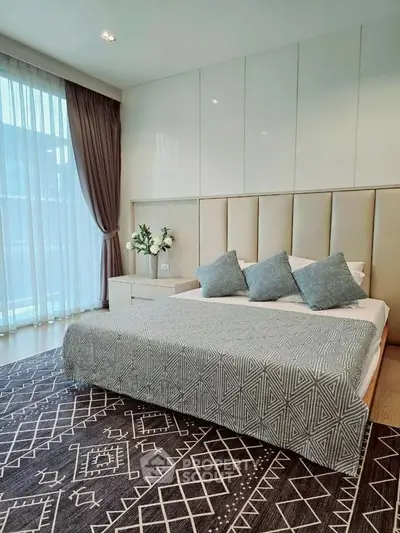 Luxurious bedroom with elegant decor and large window for natural light.