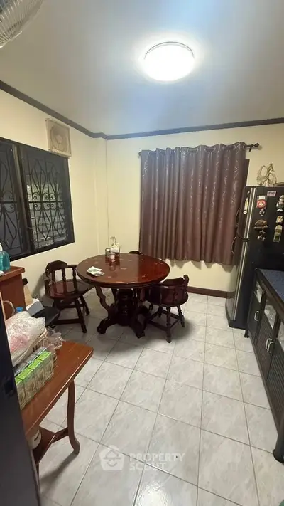 Cozy kitchen with round dining table and modern appliances, perfect for intimate meals.