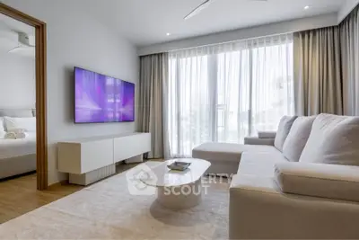 Modern living room with sleek furniture and large window, perfect for relaxation and entertainment.