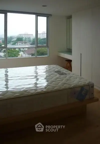 Spacious bedroom with large window offering scenic views and ample natural light.
