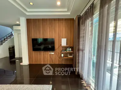 Modern living room with wall-mounted TV and elegant curtains, featuring sleek black tile flooring.