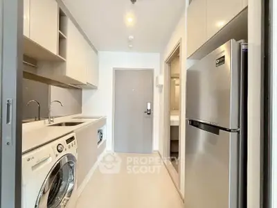 Modern kitchen with sleek appliances and washing machine in a compact layout.