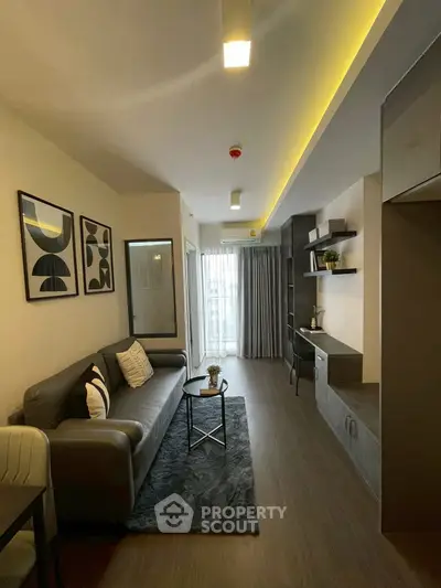 Modern living room with stylish decor and natural light, featuring a cozy sofa and elegant wall art.