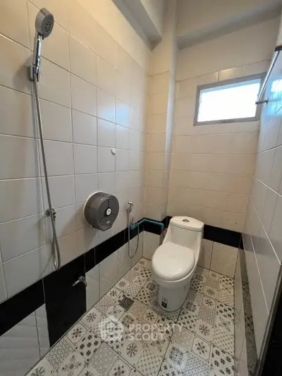Modern bathroom with stylish tiles and sleek fixtures, featuring a window for natural light.