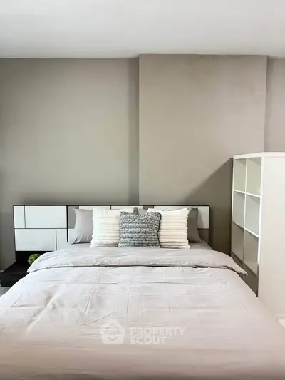 Modern bedroom with stylish decor and cozy bedding in a contemporary apartment.