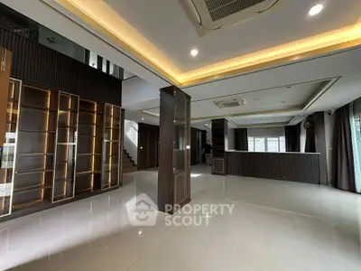 Spacious modern living room with elegant lighting and built-in shelving, perfect for luxury living.