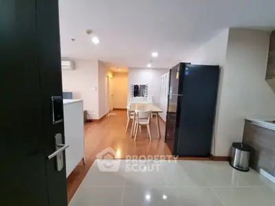 Modern open-plan kitchen and dining area with sleek appliances and wooden flooring.