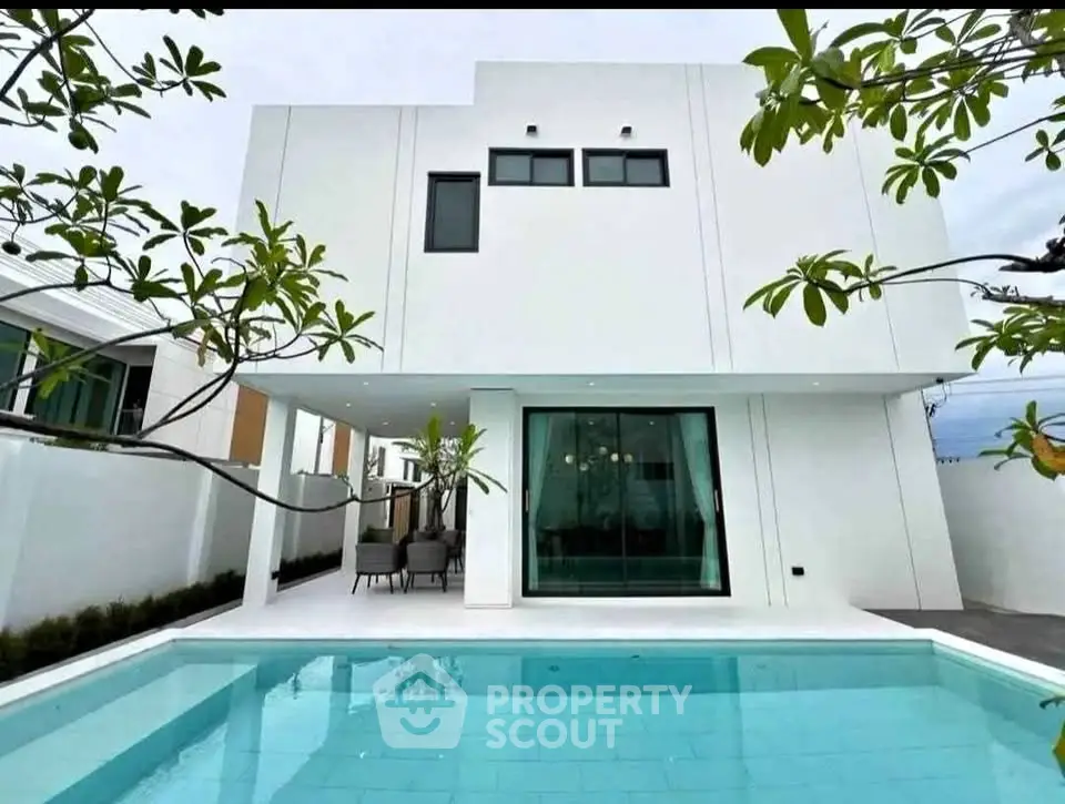 Modern white two-story house with a private pool and spacious patio area.