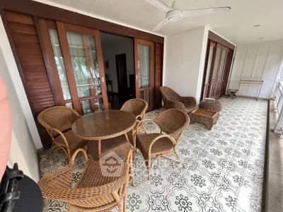 Spacious balcony with elegant wicker furniture and patterned tile flooring