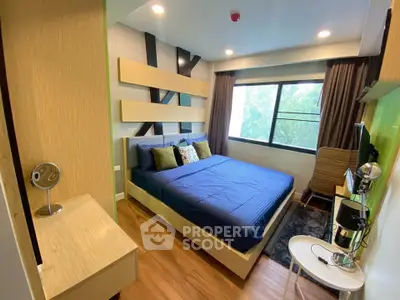 Modern bedroom with stylish decor and large window offering natural light