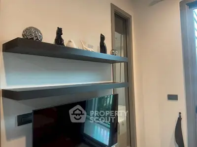 Modern living room with sleek shelves and flat-screen TV, showcasing contemporary decor and design.