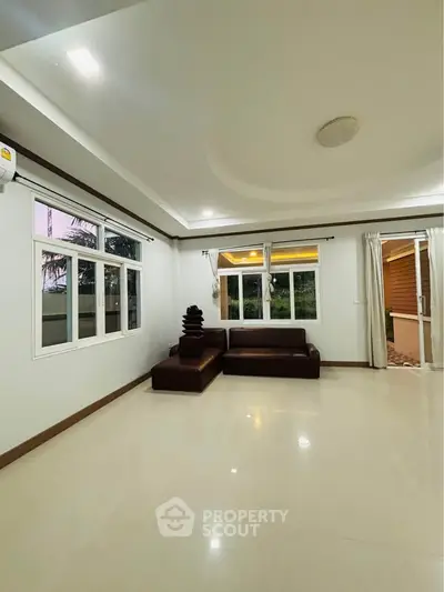Spacious living room with modern design and large windows offering natural light.