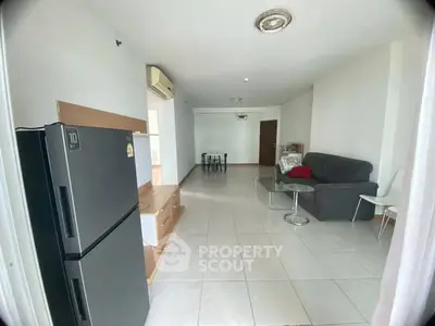 Spacious living room with modern furniture and tiled flooring in a bright apartment.