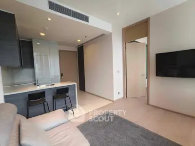 Modern open-layout living room with sleek kitchen and cozy seating area.