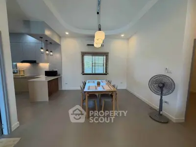 Modern dining area with stylish lighting and open kitchen layout in a contemporary home.