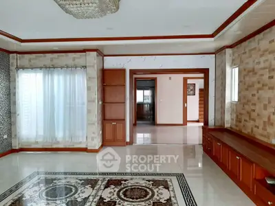 Spacious living room with elegant tile flooring and built-in wooden cabinetry