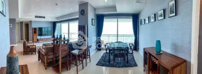 Spacious living room with ocean view, elegant wooden furniture, and modern decor in a luxury apartment.
