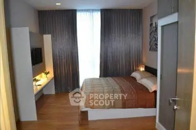 Modern bedroom with elegant decor and natural light, featuring a cozy bed and stylish curtains.