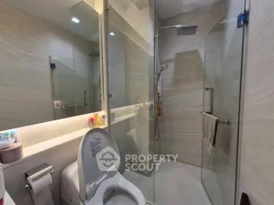 Modern bathroom with glass shower and sleek fixtures in a contemporary home.