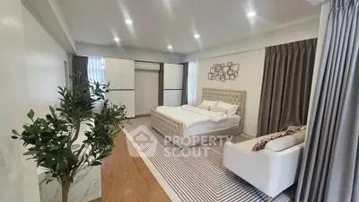 Spacious modern bedroom with elegant decor and ample natural light