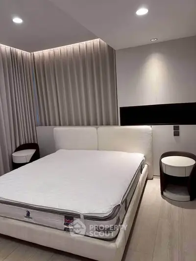 Modern bedroom with stylish furniture and ambient lighting, featuring a comfortable bed and elegant side tables.