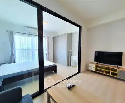 Modern apartment with glass partition, cozy living area, and natural light