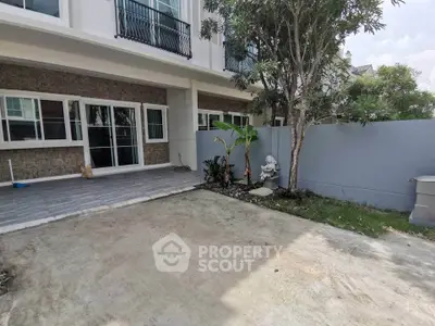 Charming townhouse exterior with private garden and patio area, perfect for outdoor relaxation.