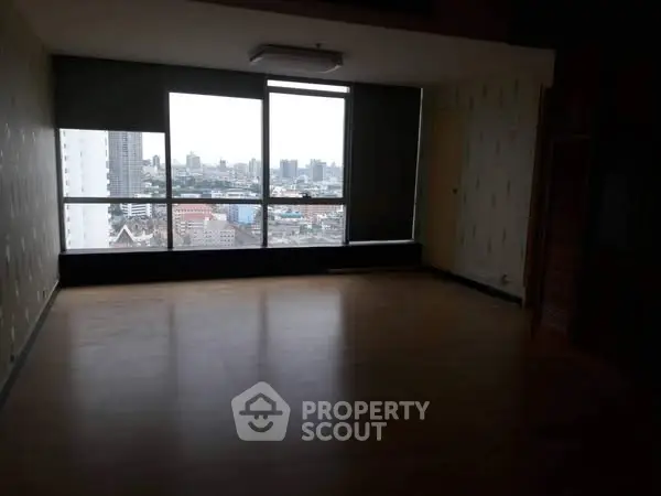 Spacious room with large windows offering a stunning city view, perfect for urban living.