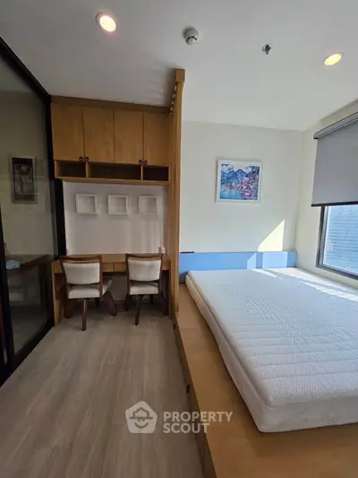 Modern bedroom with built-in desk and large window offering natural light