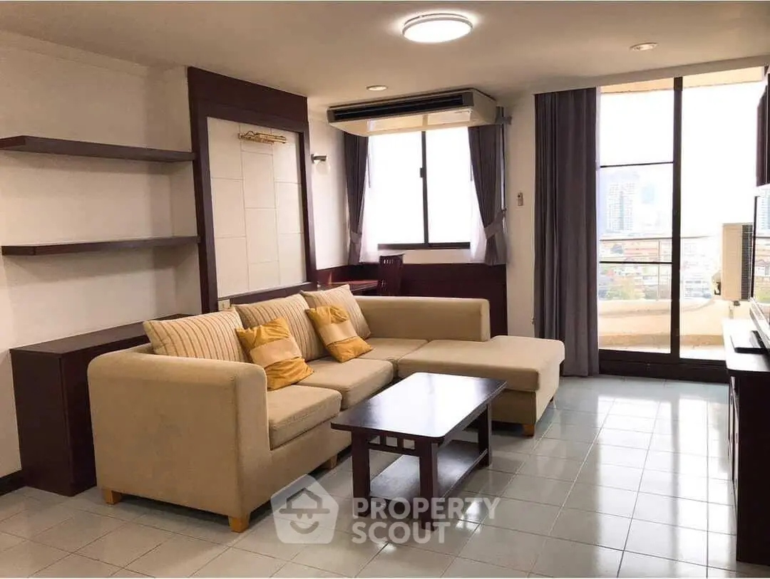 Spacious living room with modern sofa and city view balcony access.