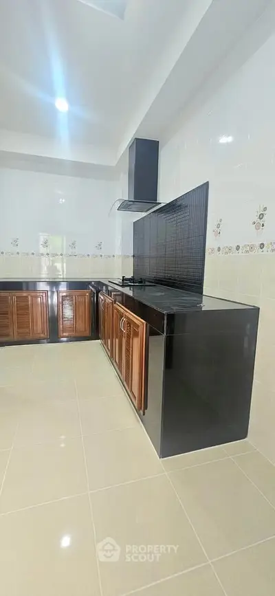 Spacious kitchen with sleek black countertops and wooden cabinets