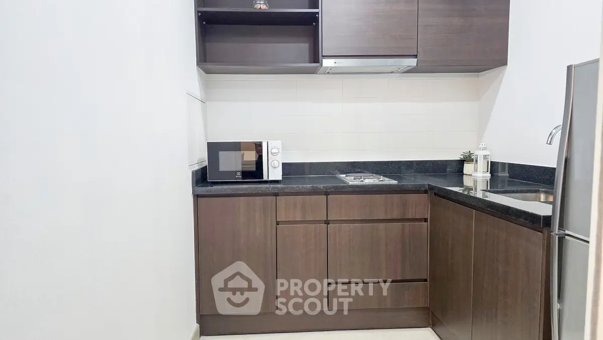 Modern kitchen with sleek cabinetry and built-in appliances in a compact layout.