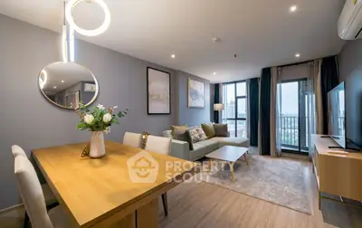 Modern living room with elegant decor and city view, featuring stylish furniture and ambient lighting.