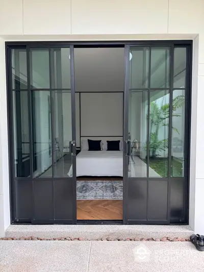 Modern bedroom with glass sliding doors and garden view