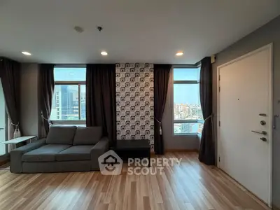 Modern living room with stylish decor and city view, featuring a cozy sofa and elegant curtains.