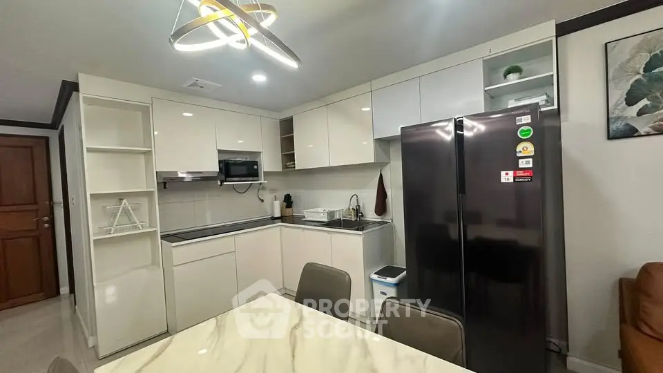 Modern kitchen with sleek cabinetry and stainless steel appliances in a stylish apartment.
