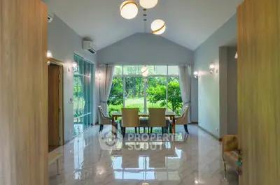 Spacious dining area with large windows and garden view, featuring elegant lighting and modern decor.