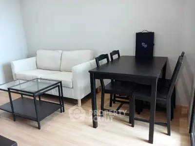 Modern living room with sleek black furniture and cozy white sofa