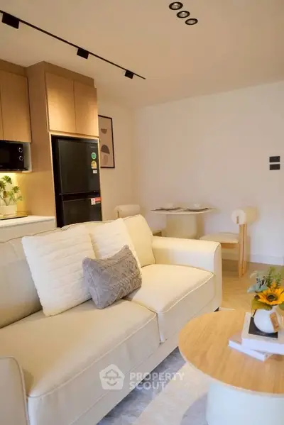 Modern living room with cozy sofa, stylish kitchen, and elegant dining area in open layout apartment.