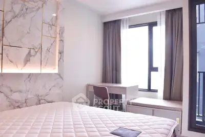 Luxurious bedroom with marble accent wall and large window for natural light.