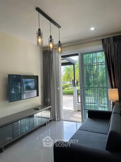 Modern living room with sleek furniture and large glass doors opening to a lush garden view.