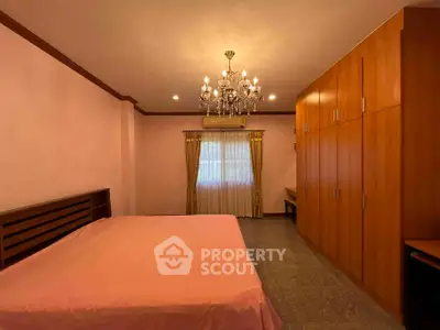 Spacious bedroom with elegant chandelier and ample closet space