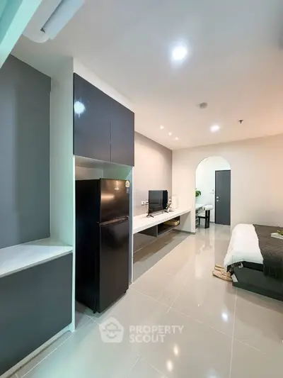 Modern studio apartment with sleek design and open layout, featuring a cozy living area and contemporary kitchen.