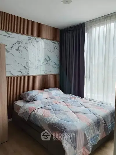 Modern bedroom with stylish wood paneling and large window for natural light.