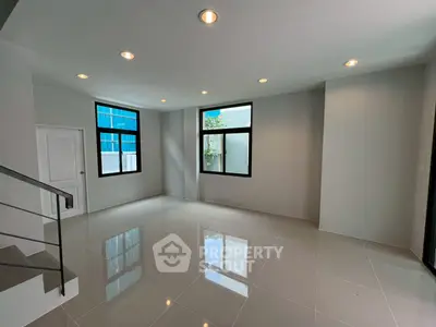 Spacious modern living room with large windows and sleek tile flooring