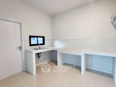 Spacious minimalist kitchen with sleek countertops and modern fixtures, perfect for culinary enthusiasts.
