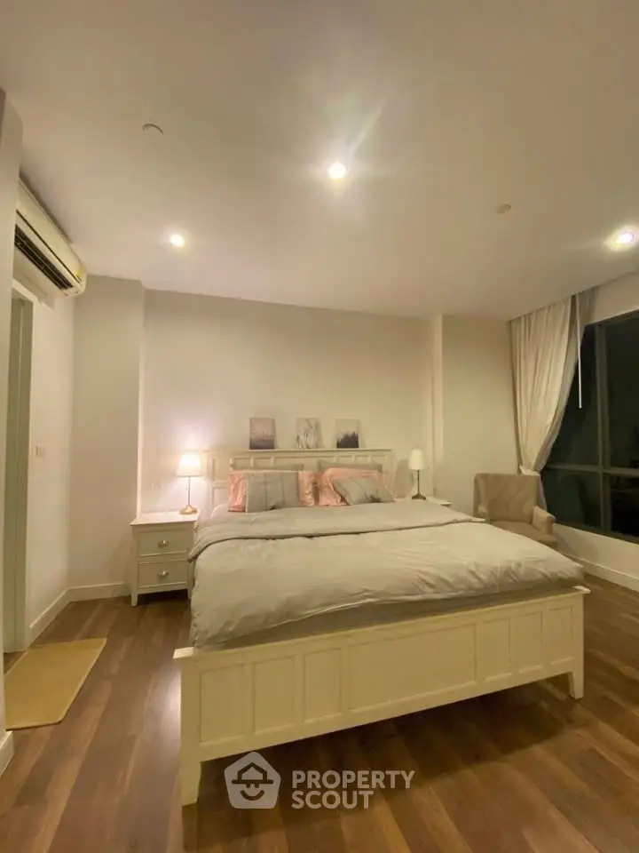 Spacious bedroom with elegant decor and cozy lighting in modern apartment.