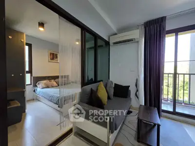Modern apartment with cozy living room and bedroom, featuring large windows and balcony access.