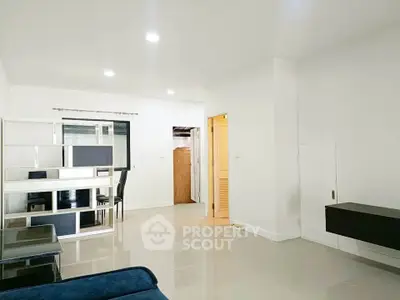 Spacious modern living room with sleek furniture and bright lighting, perfect for comfortable living.